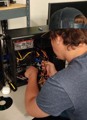 student working with wires in a computer