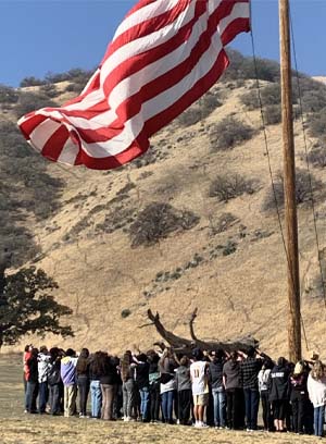 Large American flag with people gathered under it