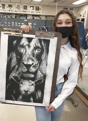 student displaying her artwork